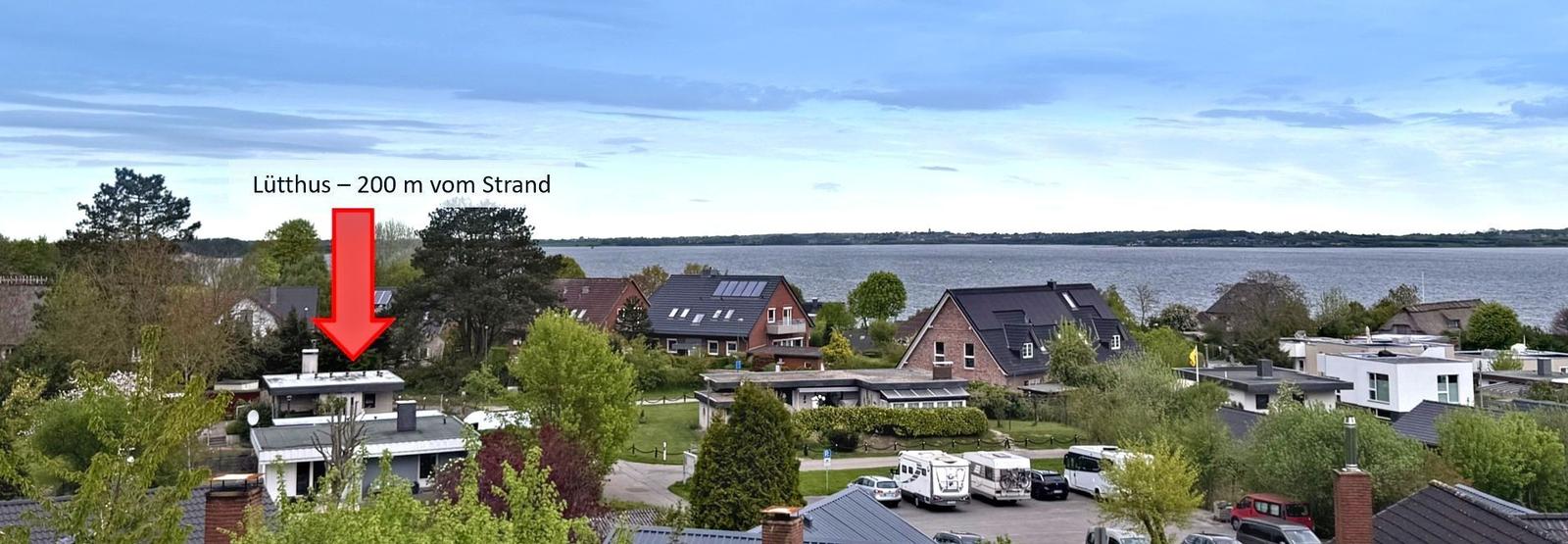 Lütthus liegt 200 m vom Strand entfernt. Blick auf Wohnhäuser und Wasser.