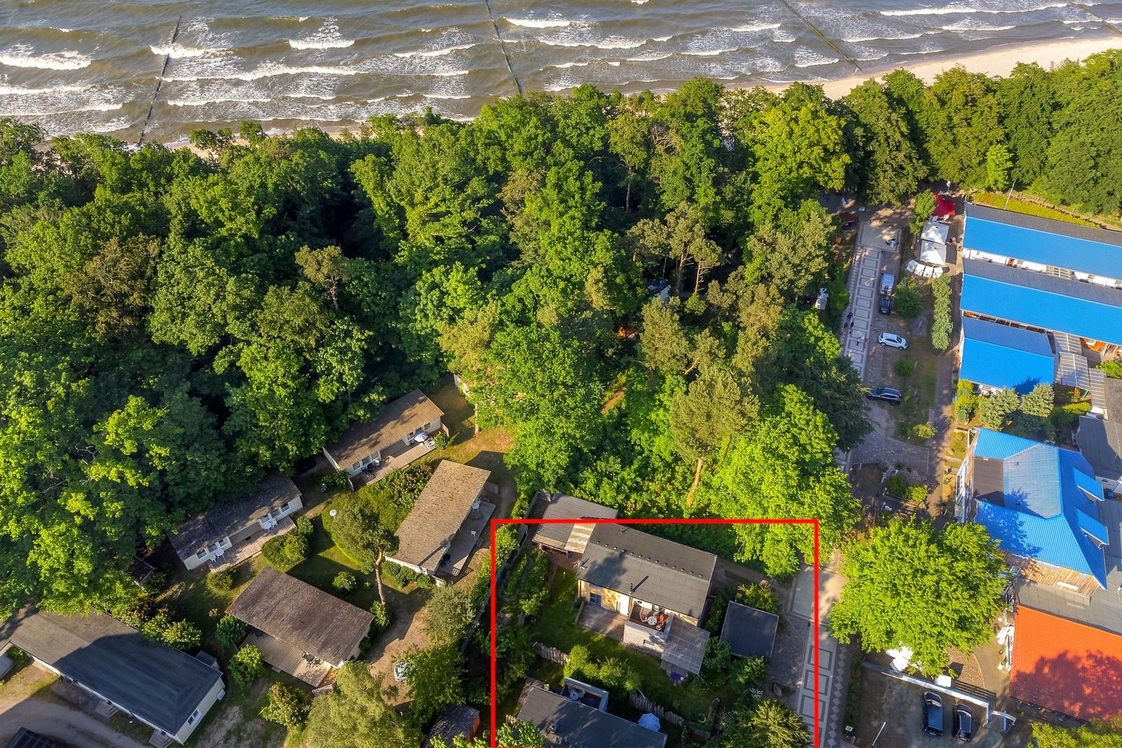 Haus mit Garten, umgeben von Wald und Strand