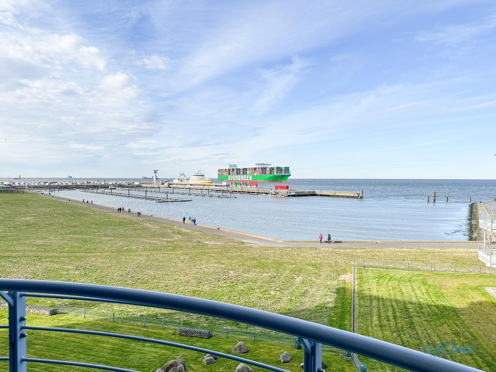 Blick auf Hafen mit Containerschiff und Promenade