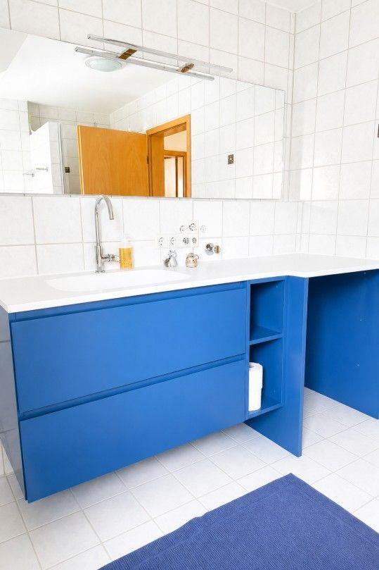 Badezimmer mit blauem Waschbeckenunterschrank und Spiegel