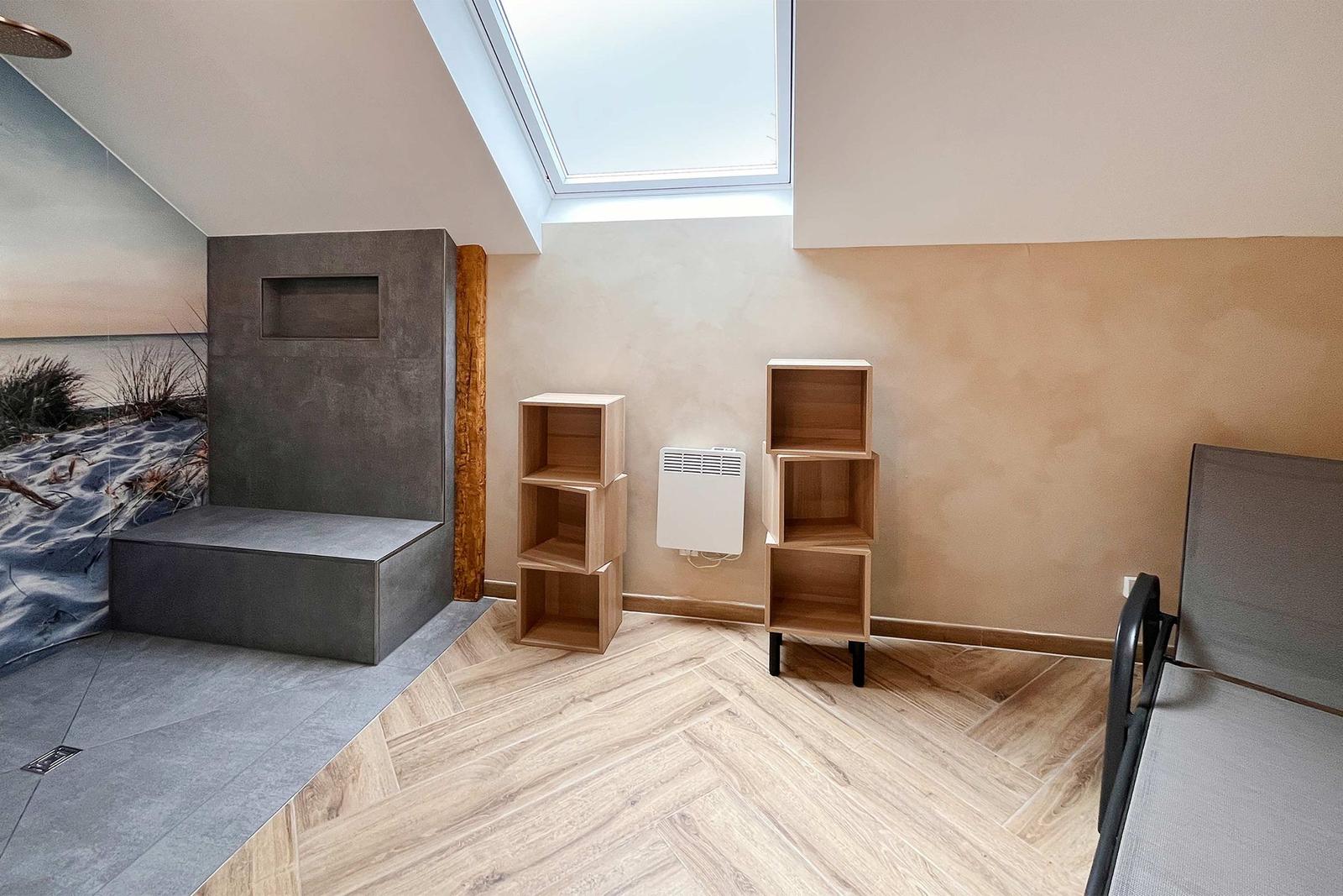 Raum mit Dachschrägen, Holzboden, Skylight und integriertem Sitzbereich mit Wandbild.