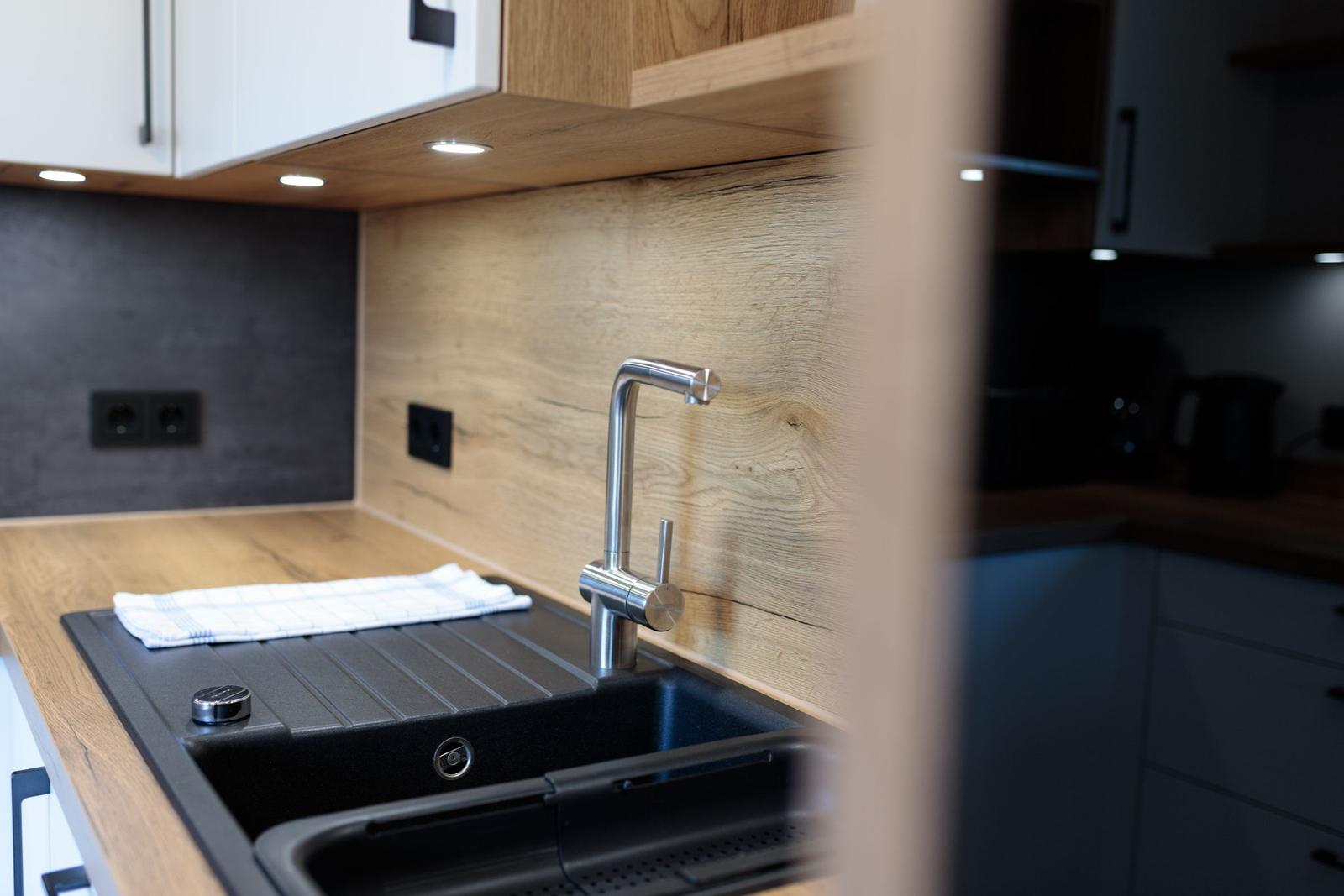 Küchenarbeitsfläche mit Spüle und modernem Wasserhahn