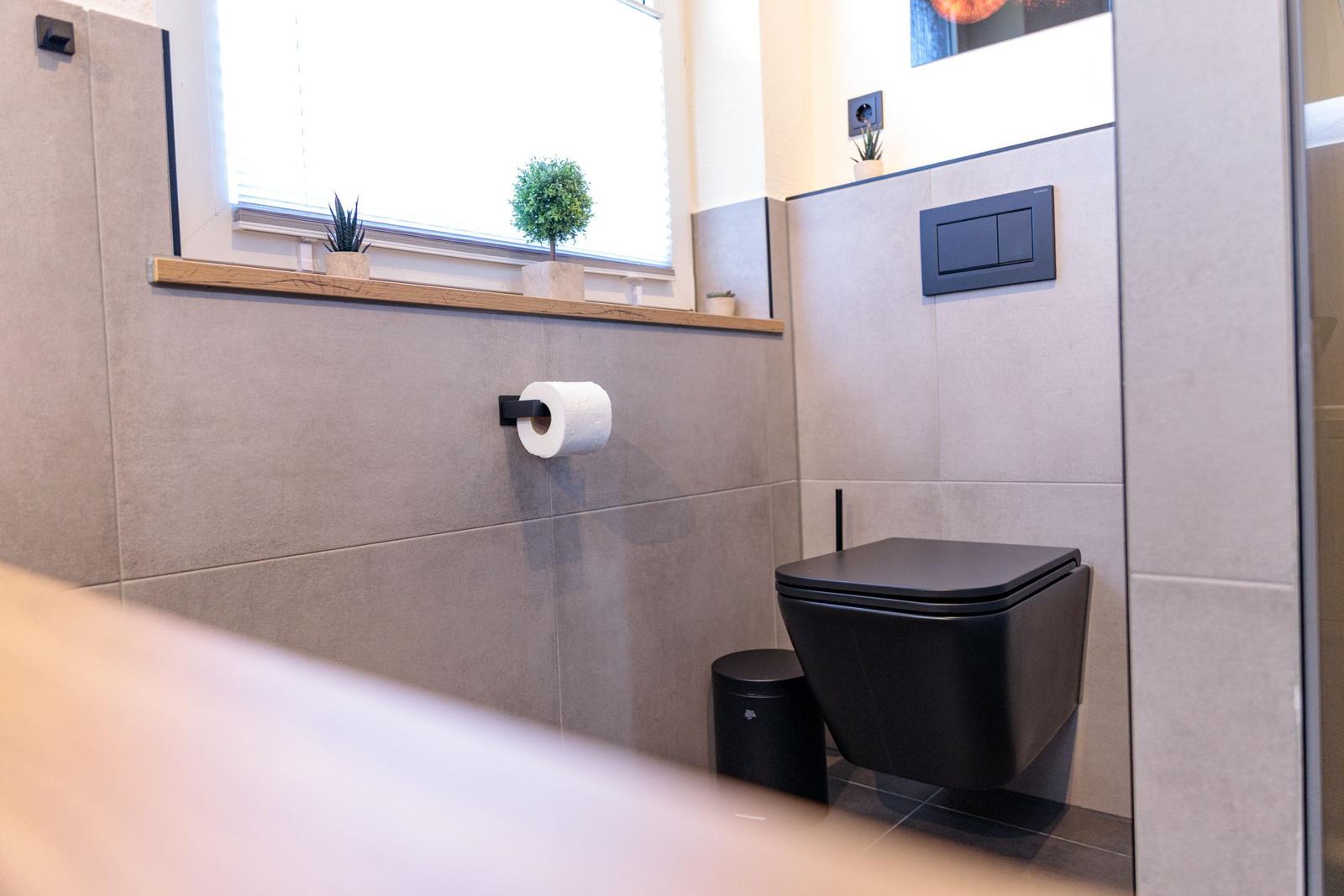 Sanitärzimmer mit Toilette, Pflanzen und Fenster