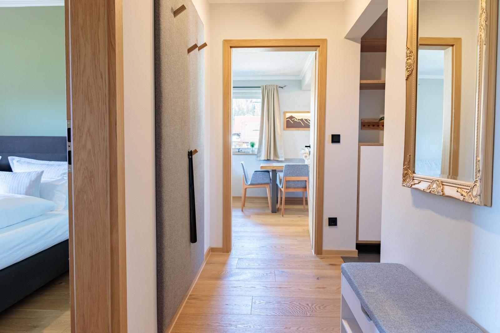Flur mit Blick in Schlafzimmer und Essbereich mit Holzboden und Spiegel