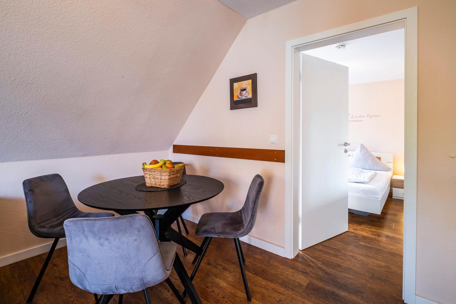 Essbereich mit runder Tisch und drei Stühlen. Durchgang zur Schlafzimmer.