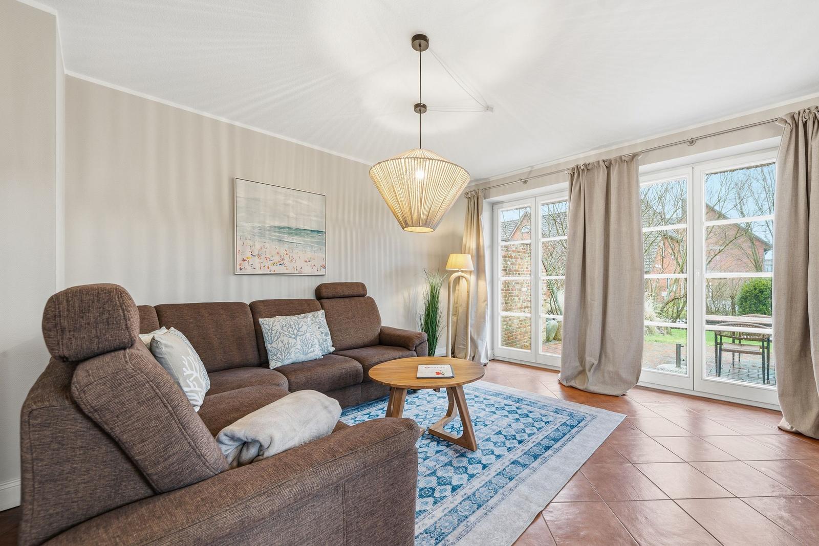 Wohnzimmer mit Sofa, Tisch und Blick auf Garten