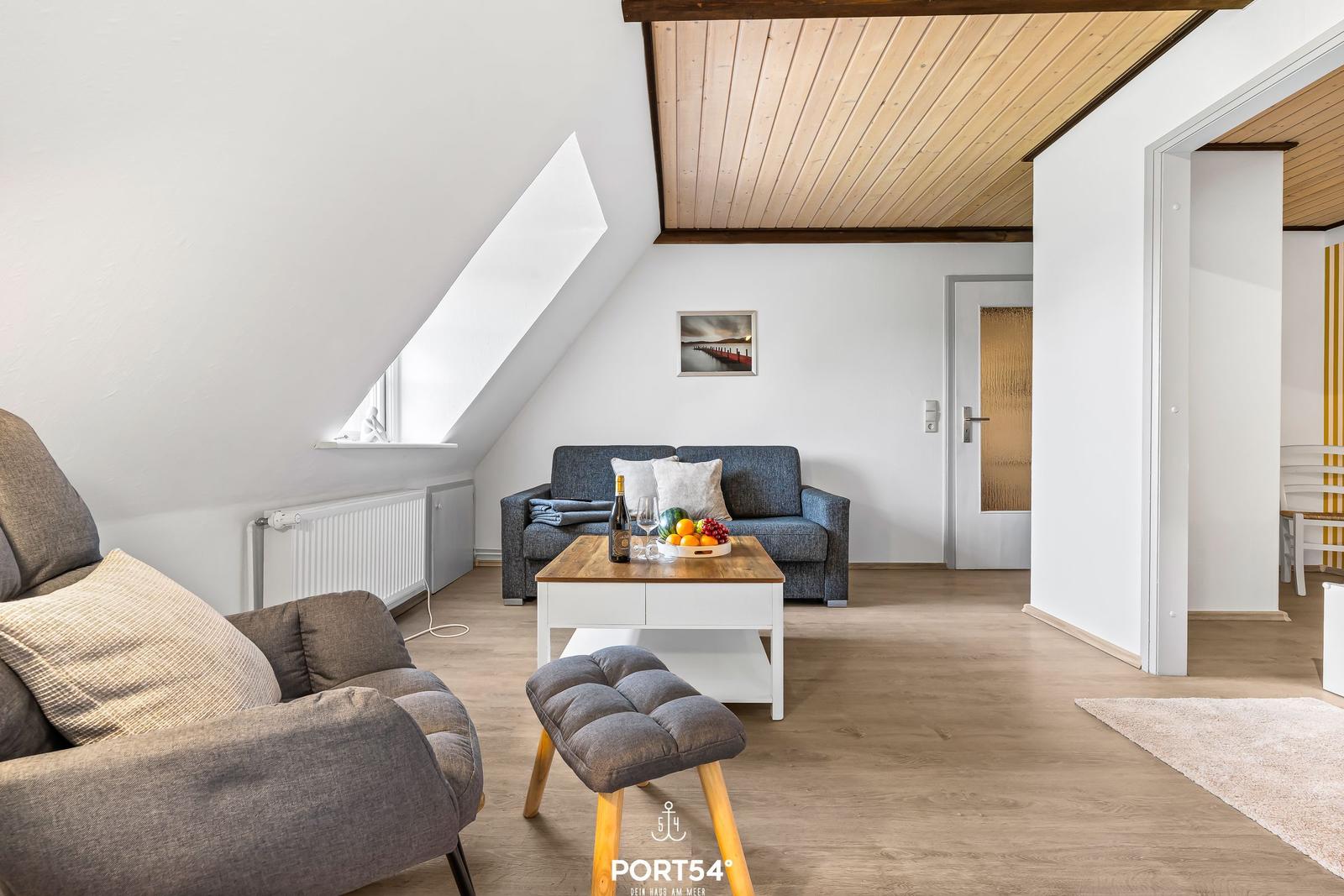 Wohnraum mit Sofa, Sitzbank und Holztisch unter Holzdecke