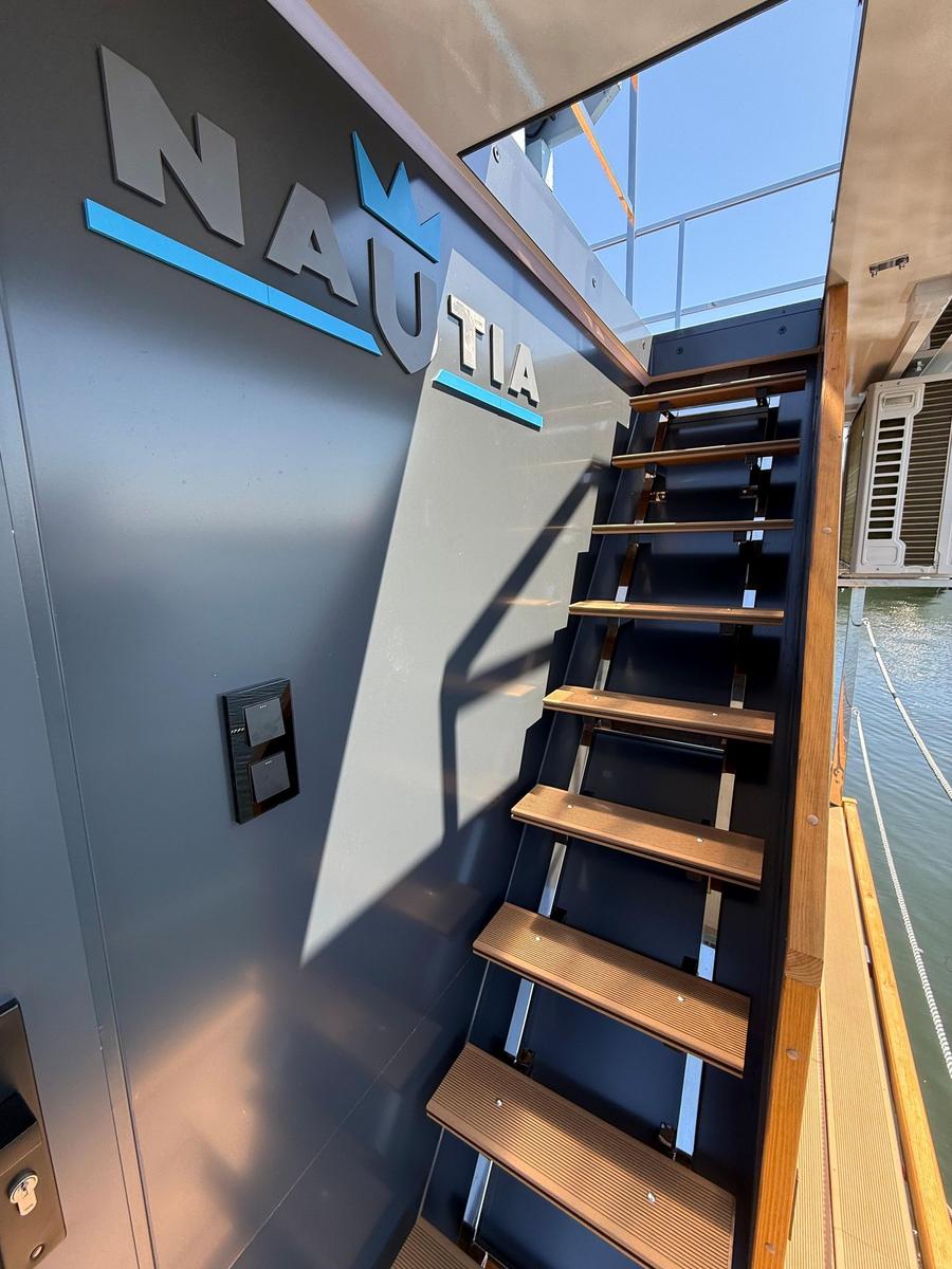 Staircase to deck with NAUTIA logo on wall