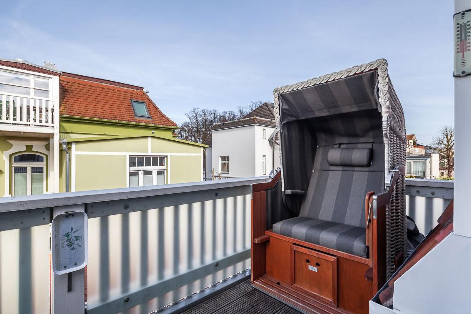 Dachterrasse mit Strandkorb und Blick auf Wohnhäuser.
