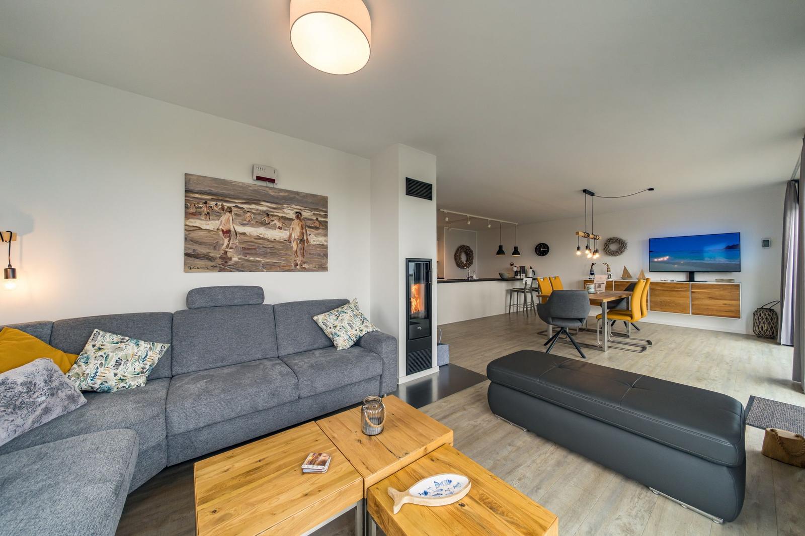 Wohn- und Essbereich mit Sofa, Kamin und Fernseher.