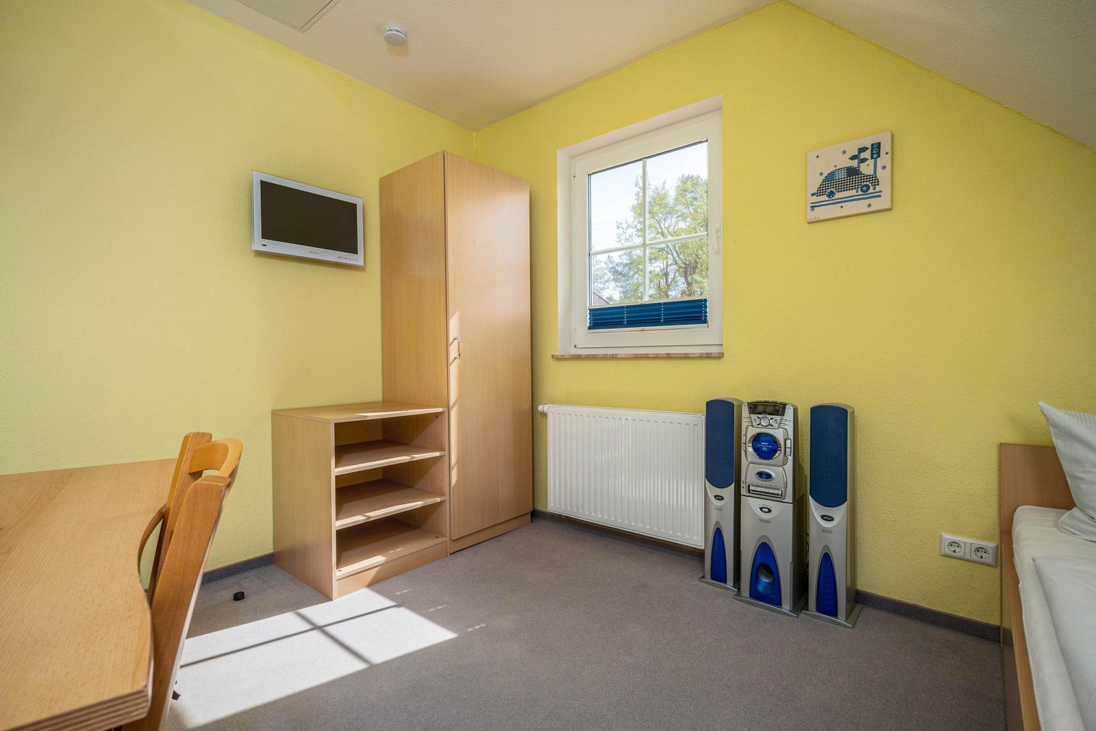Schlafzimmer mit zwei Einzelbetten und TV