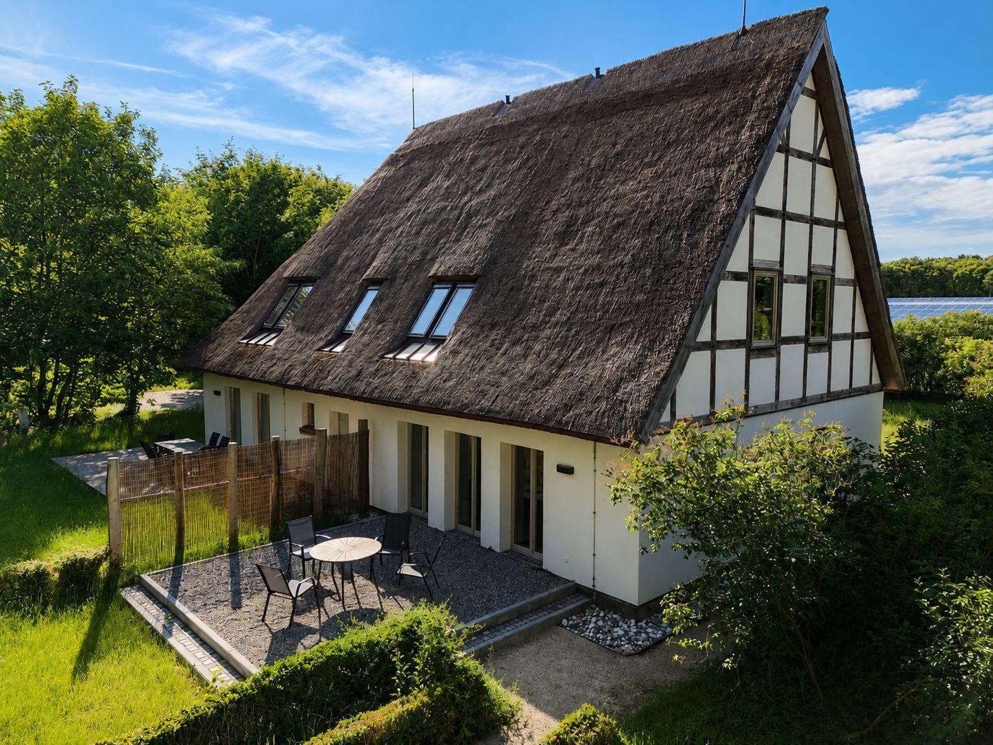 Haus mit Strohdach und Terrasse im Grünen