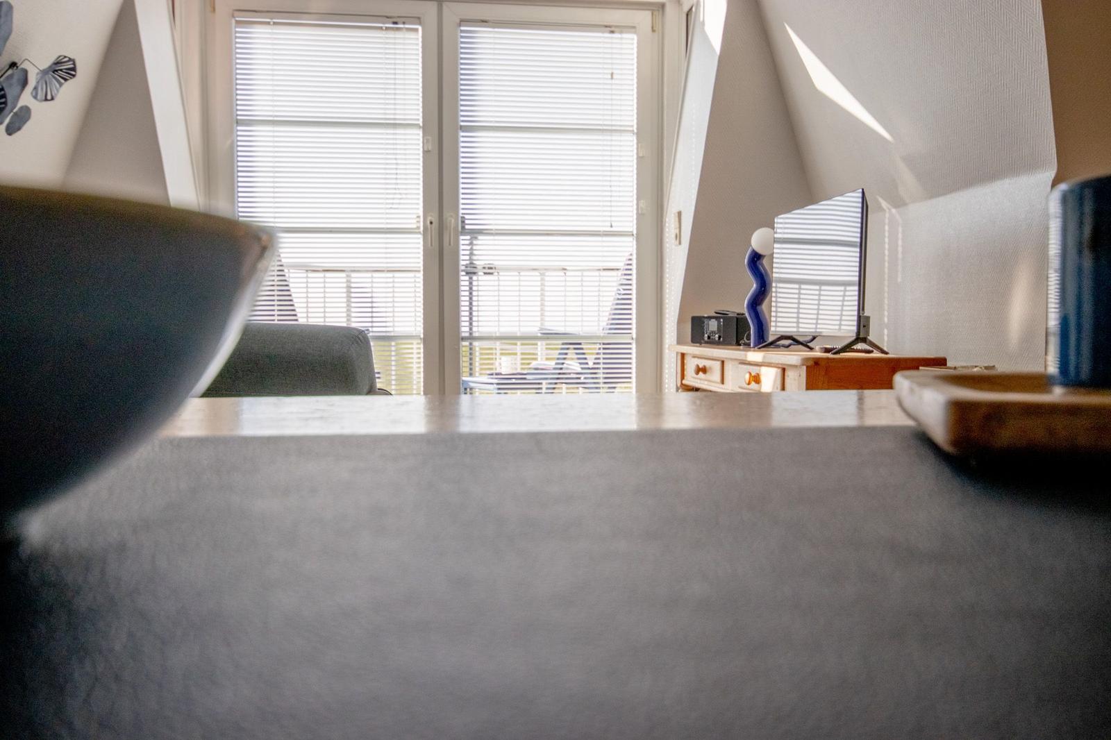 Ein Raum mit Blick auf Balkon, Fernseher und Schrank