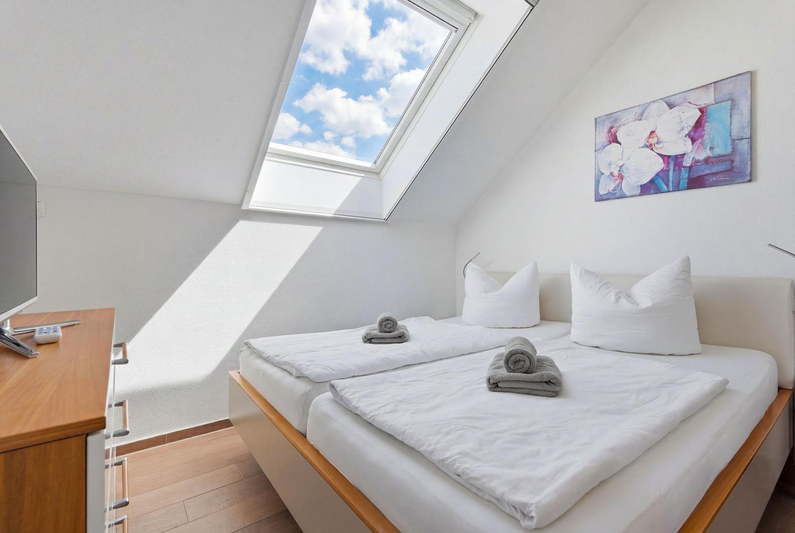 Schlafzimmer mit Doppelbett und TV