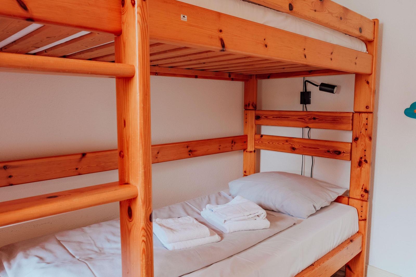 Holz-Etagenbett mit Matratzen und Handtüchern