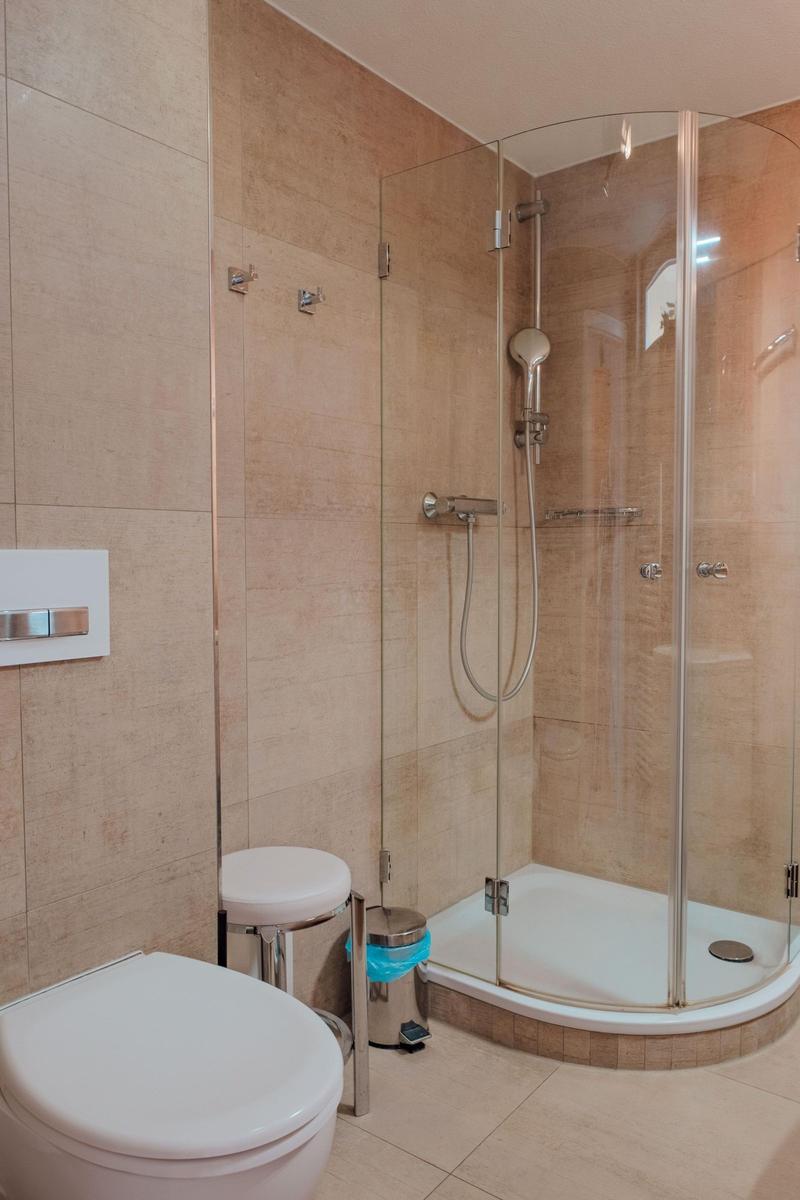 Bad mit Dusche, Toilette und Sitzhocker