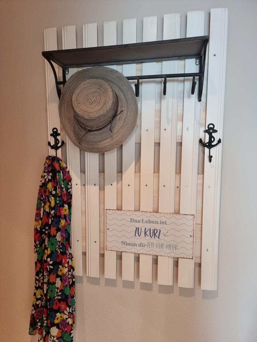 Wall rack with hat and dress, sign with sea symbols
