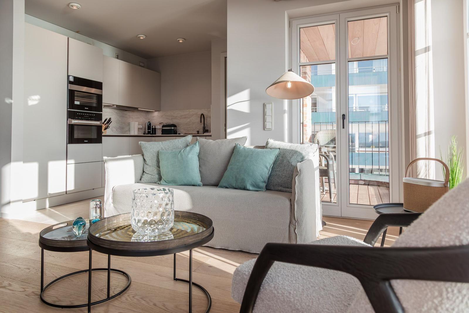 Wohnbereich mit Sofa, Küchenzeile und Terrasse mit Blick.