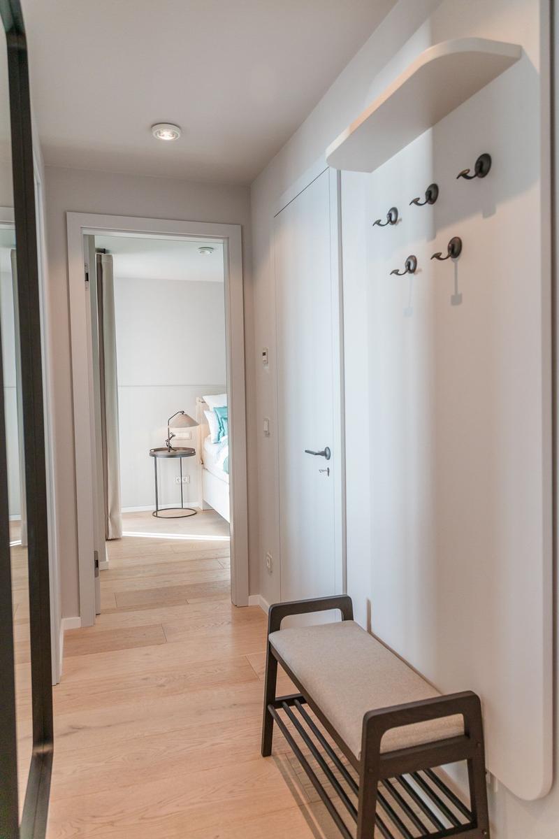 Flur mit Hocker, Garderobenstange und Blick in Schlafzimmer