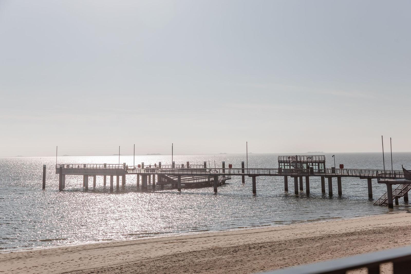 Ein Blick auf einen Steg am Strand mit Blick auf das Meer.