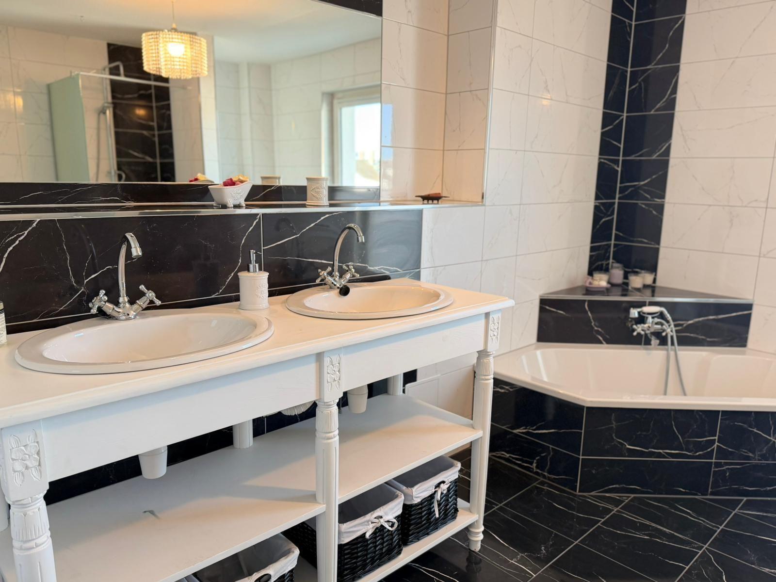 Doppelwaschbecken mit Spiegel und Badewanne in schwarz-weißem Marmor