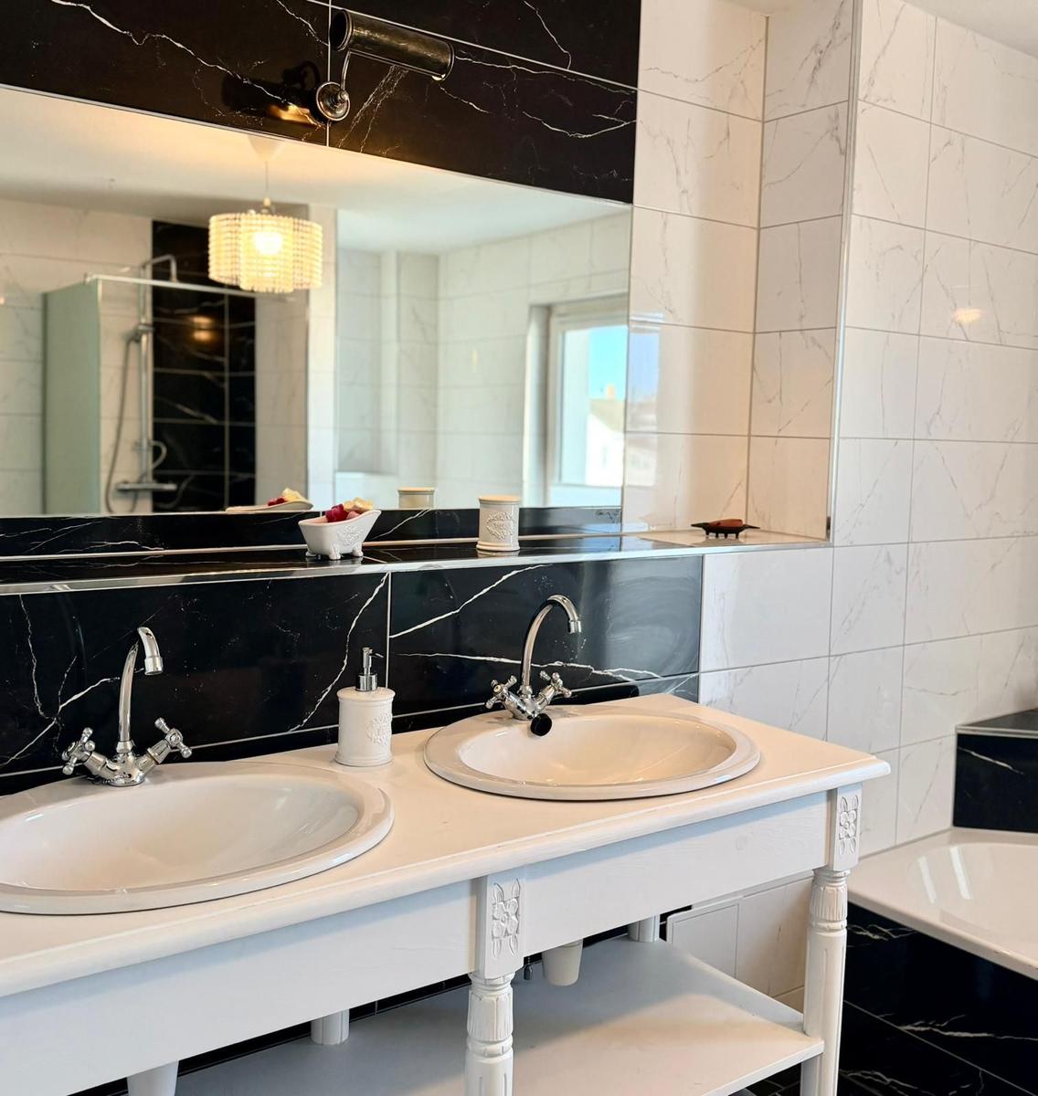 Badezimmer mit zwei Waschbecken, Spiegel und Dusche.