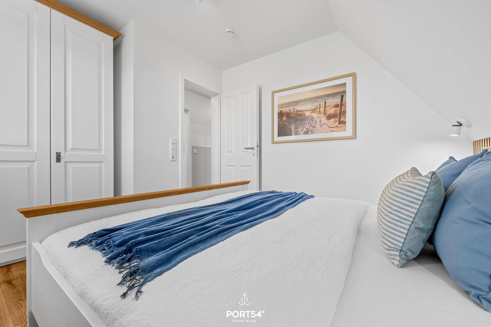 Bedroom with bed, wardrobe, and wall picture