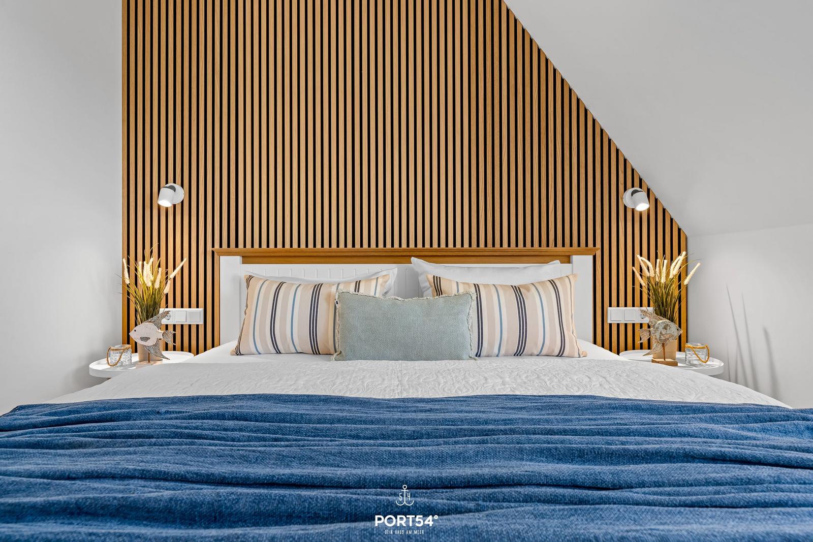 Schlafzimmer mit Holzwand, Bett und Nachttischen