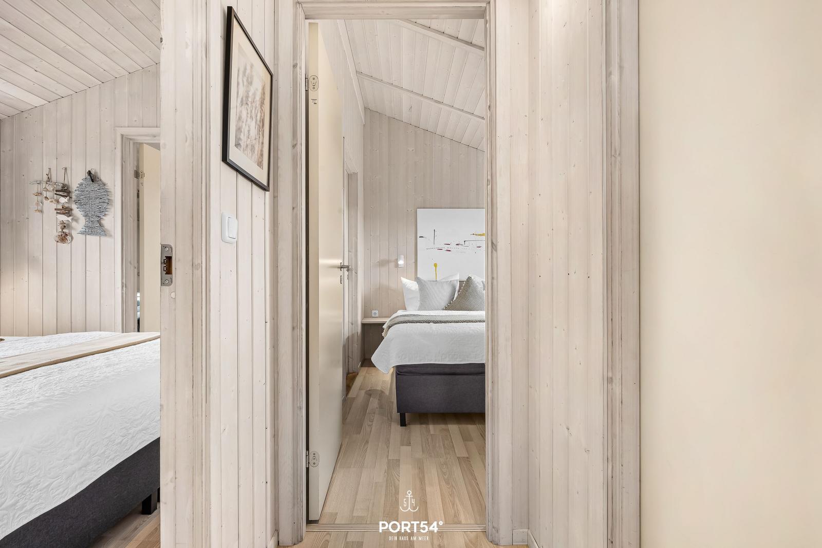 Zimmer mit Holzwand und Bett im Flur