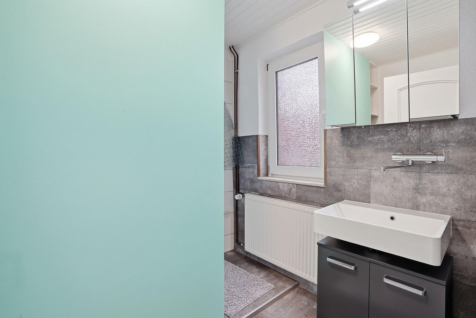 Bathroom with sink, mirror, and window