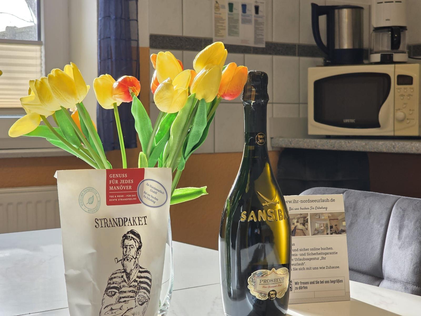 Tisch mit Tulpen, Prosecco und Strandpaket im Wohnbereich