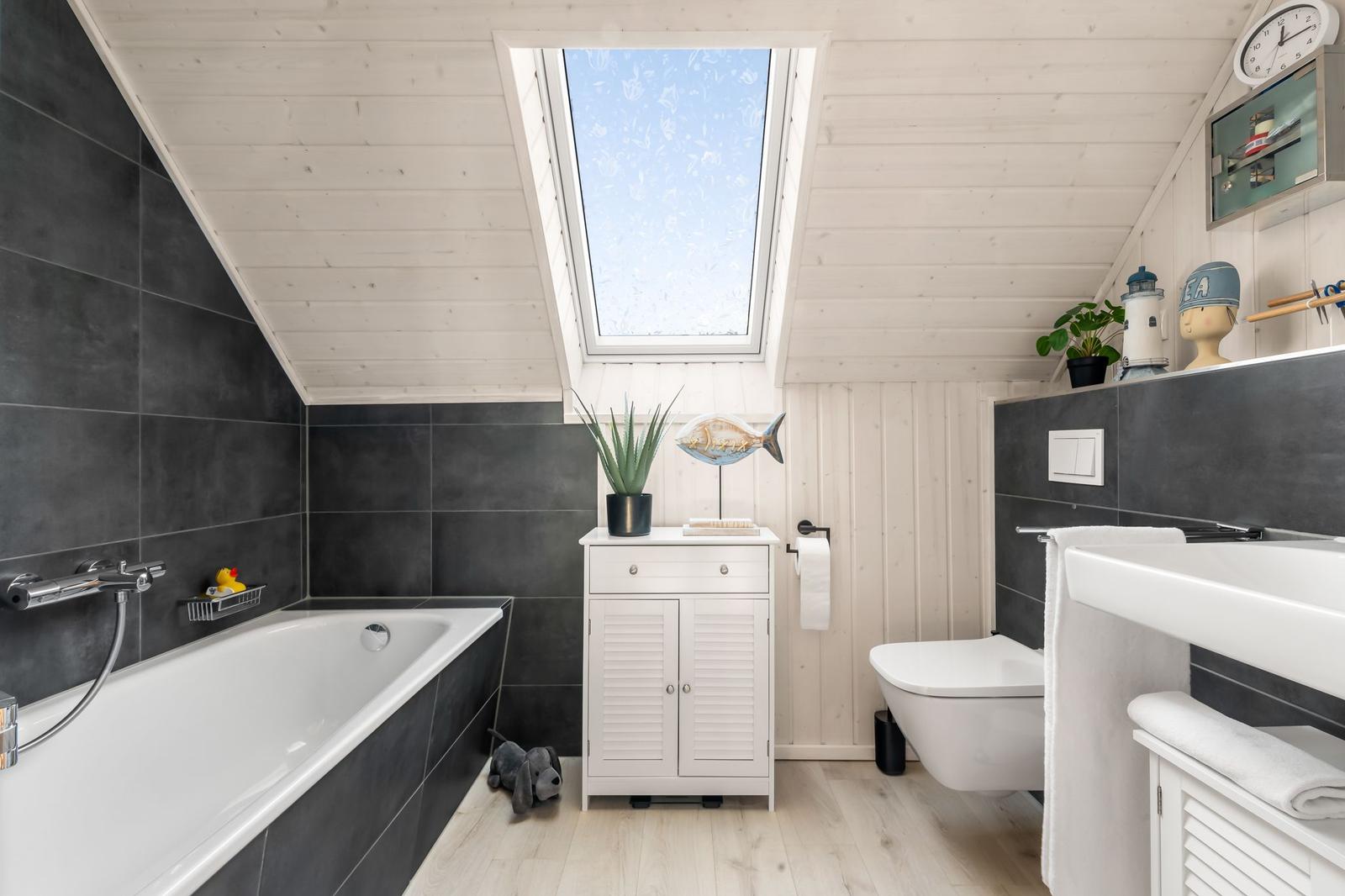 Dusche mit Dachfenster, Badewanne, Toilette und Waschbecken