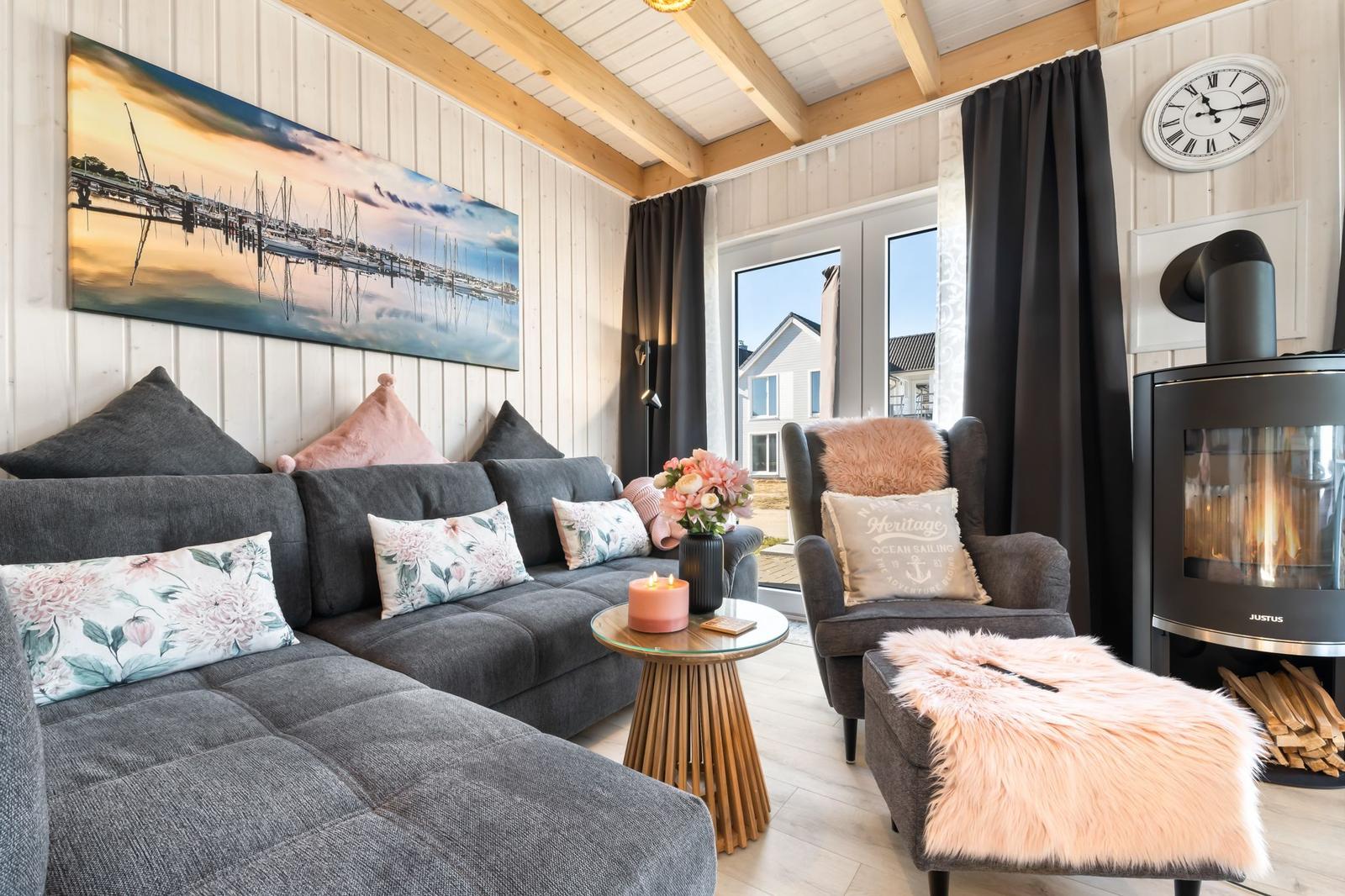 Wohnzimmer mit Sofa, Sessel, Kamin und Wandbild.