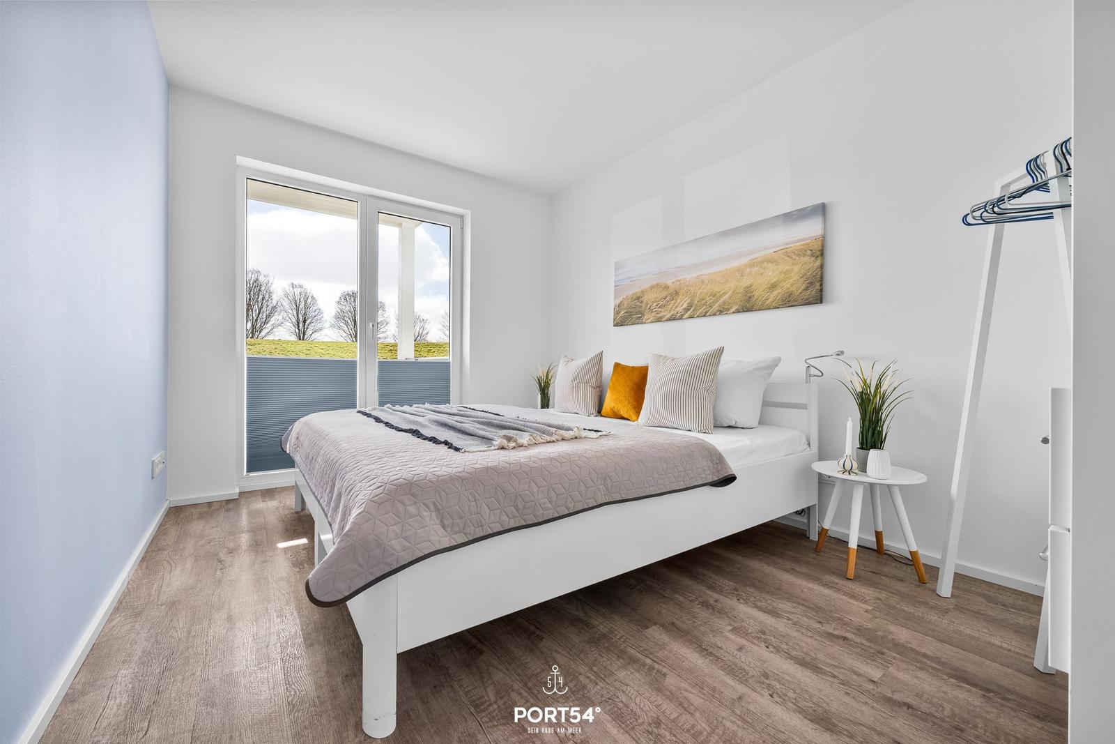 Schlafzimmer mit Bett, Fenster und Wandbild