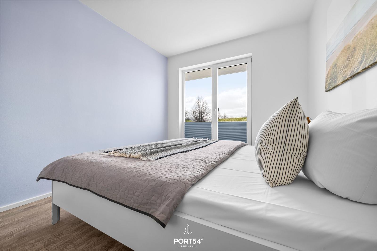Schlafzimmer mit Bett, Fenster und Wandbild