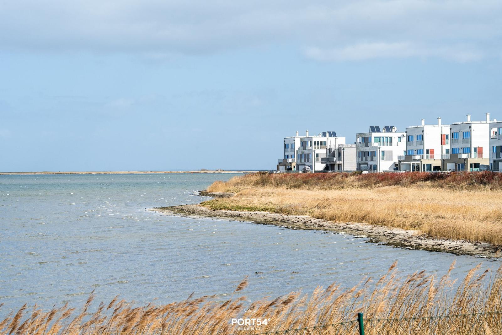 Wohnhaus am Wasser mit Schilf und Blick auf die Küste