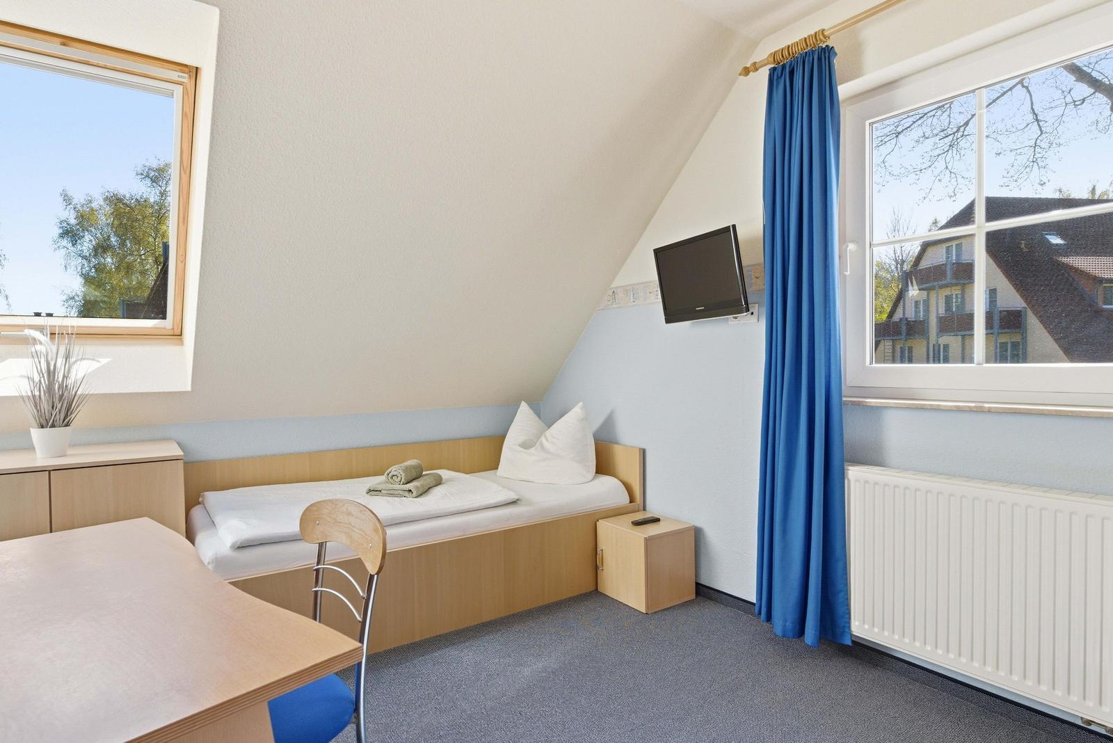 Schlafzimmer mit zwei Einzelbetten und TV