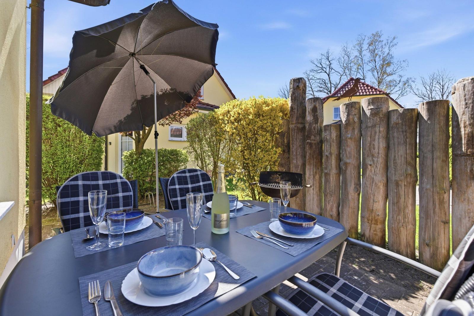 Terrasse mit Sonnenschirm und Grill