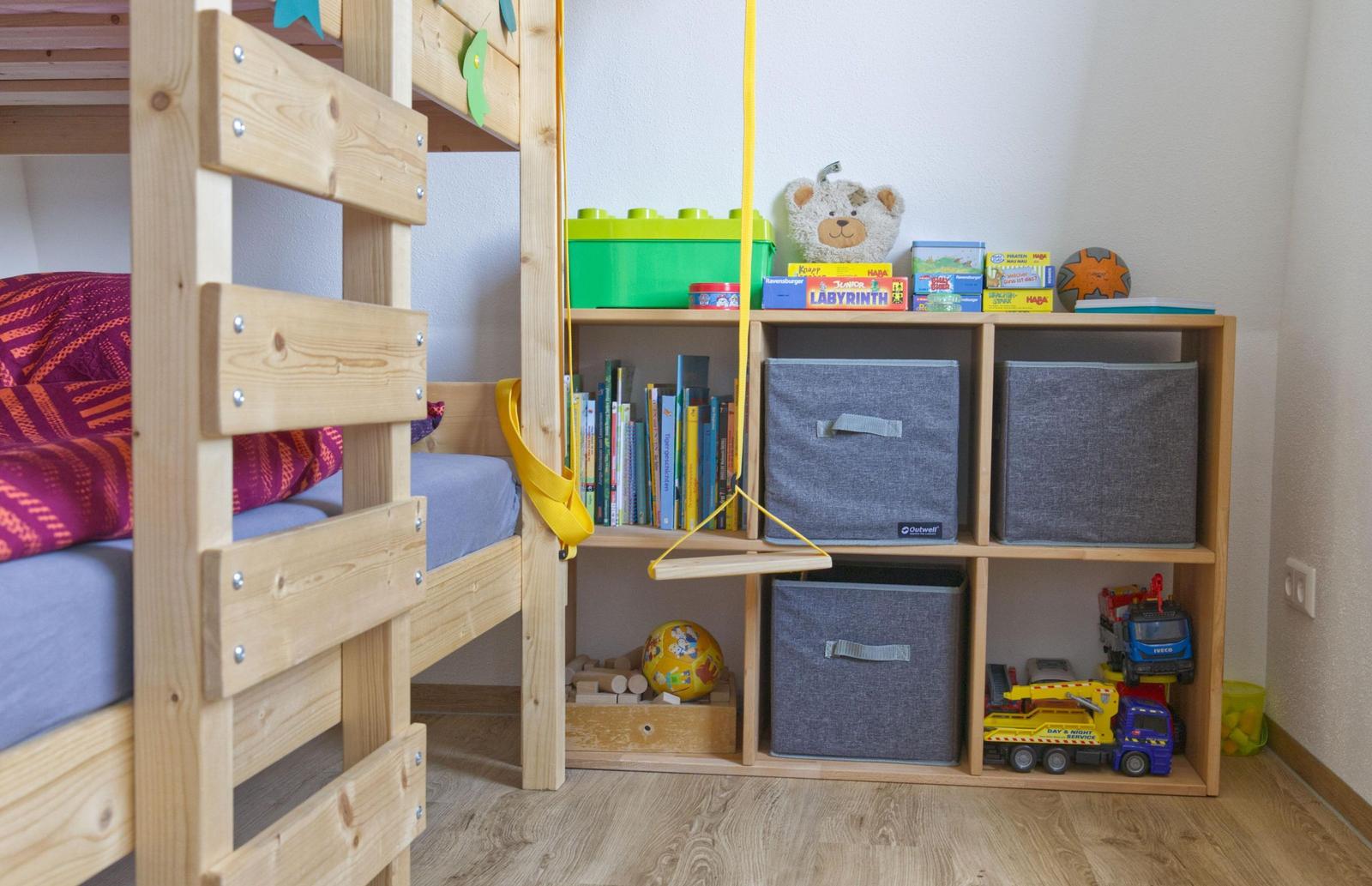 Kinderzimmer mit Holzbett und Spielzeugregal