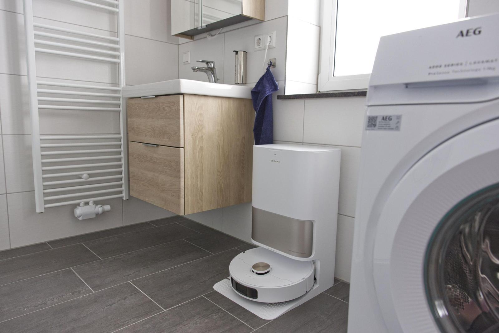 Badezimmer mit Waschmaschine, Handtuch und Spiegelschrank.