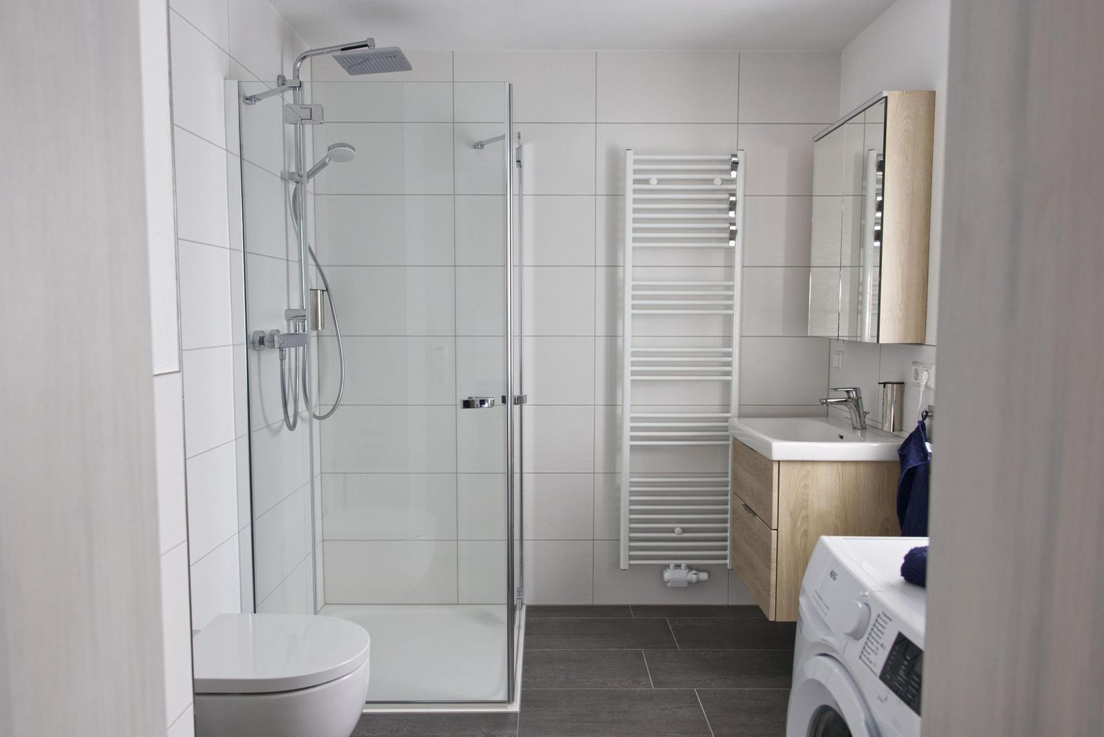 Bad mit Dusche, Waschbecken und Wärmewasserspender