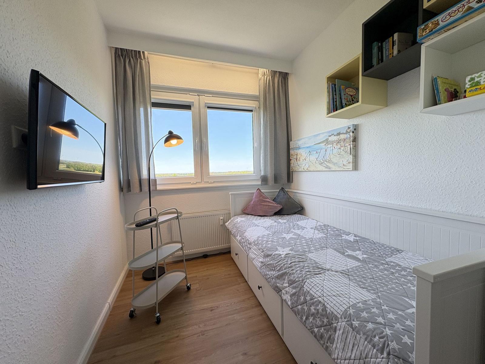 Schlafzimmer mit Bett, TV und Fenster mit Blick.