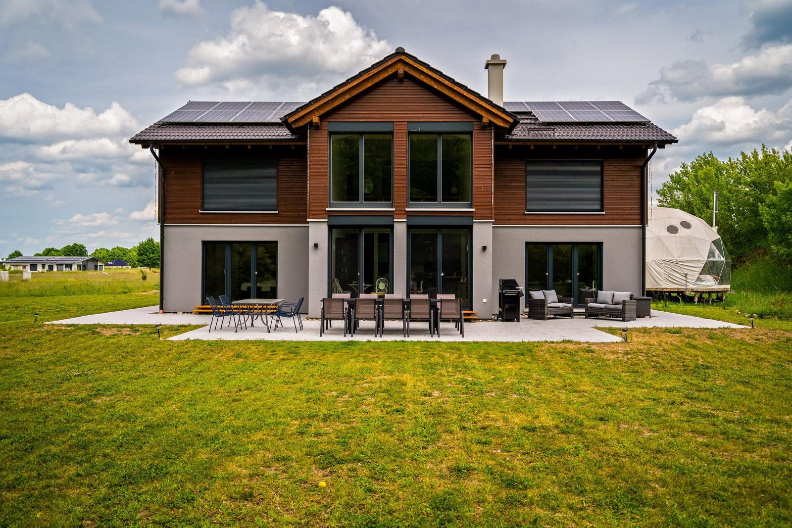 Moderne Villa mit Solaranlage und großem Garten. Terrasse mit Sitzgelegenheiten und Grill.