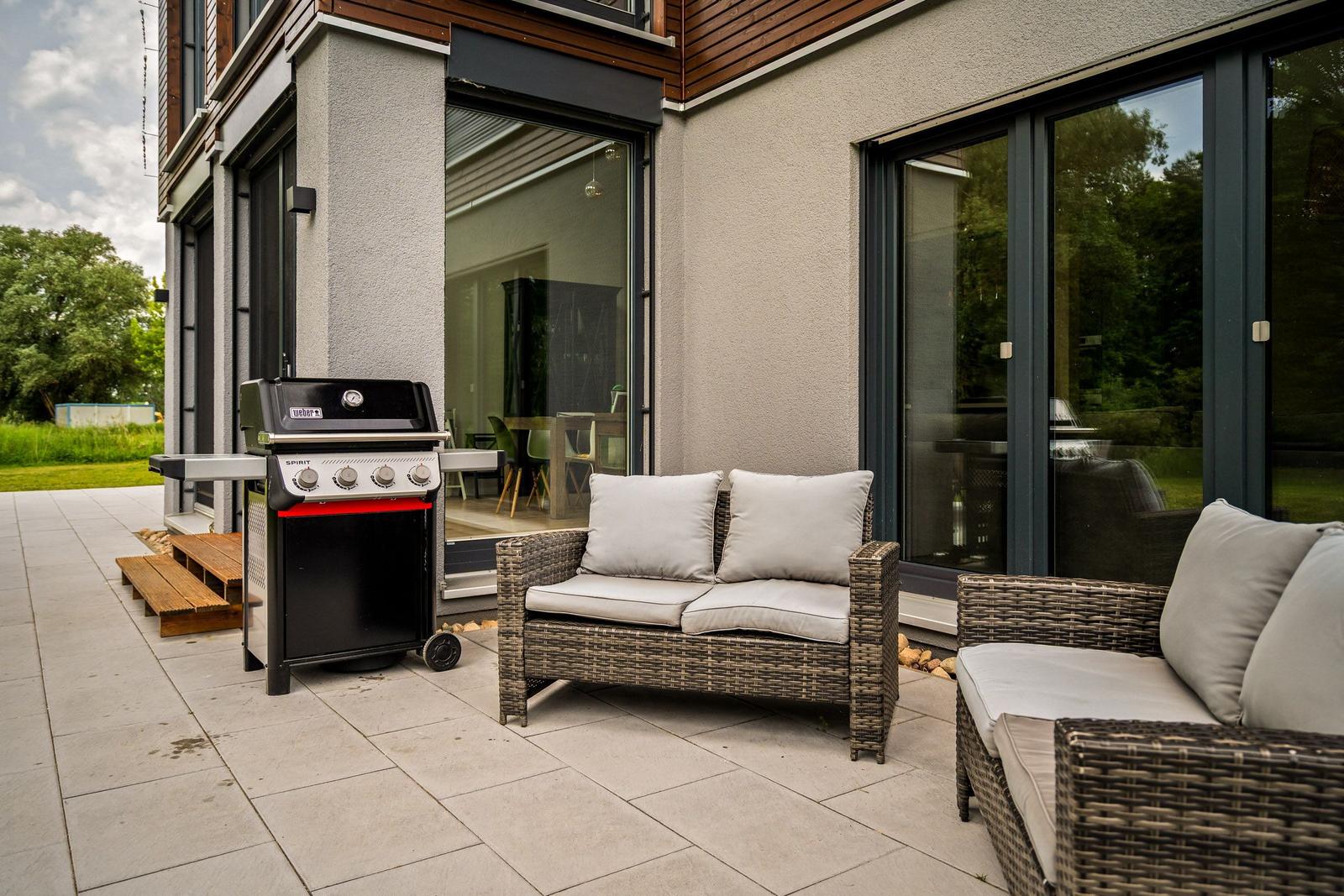 Terrasse mit Grill, Sitzgruppe und Blick ins Haus