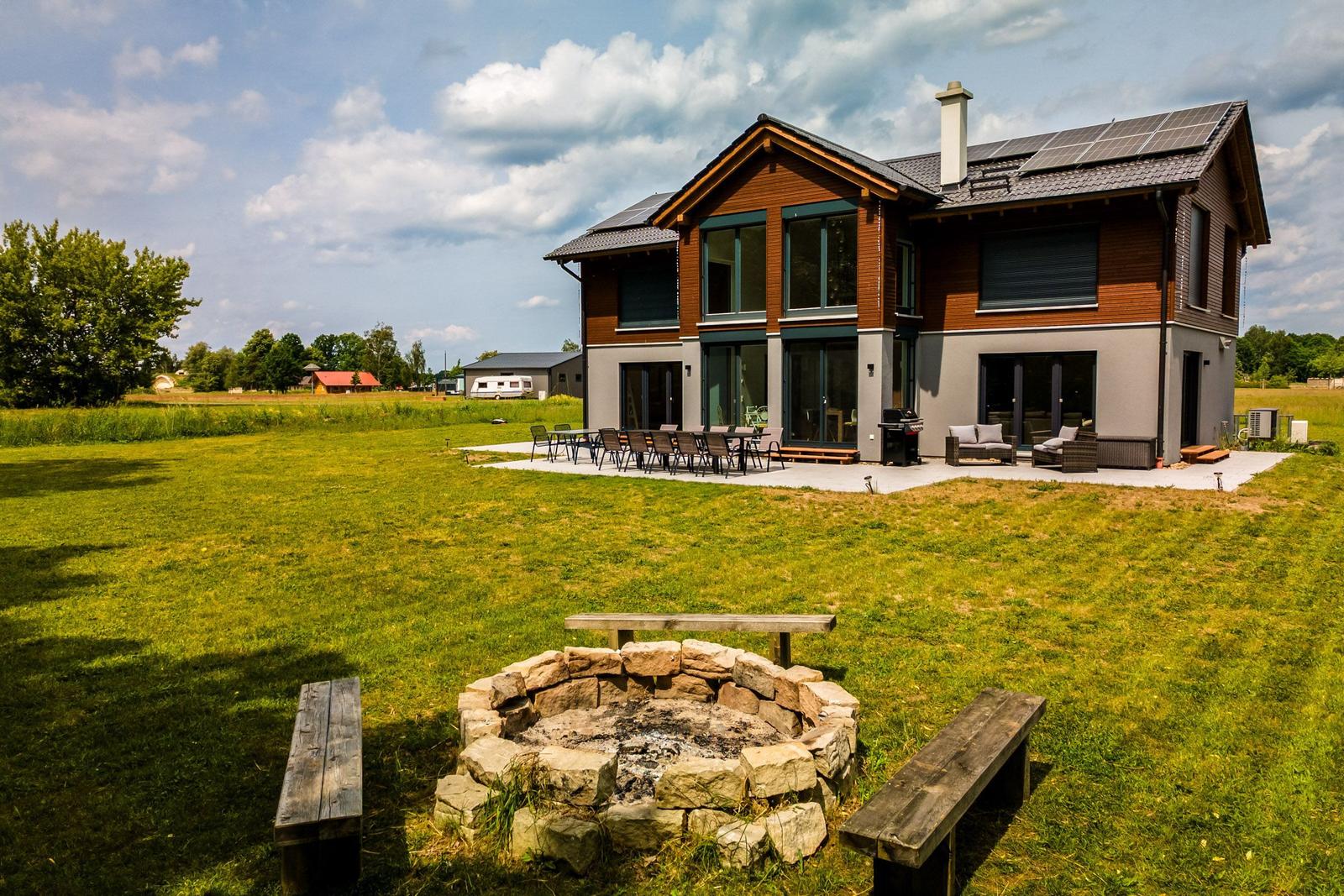 Moderne Villa mit großem Garten, Grillplatz und Steinfeuer. Terrasse mit Sitzgelegenheiten.