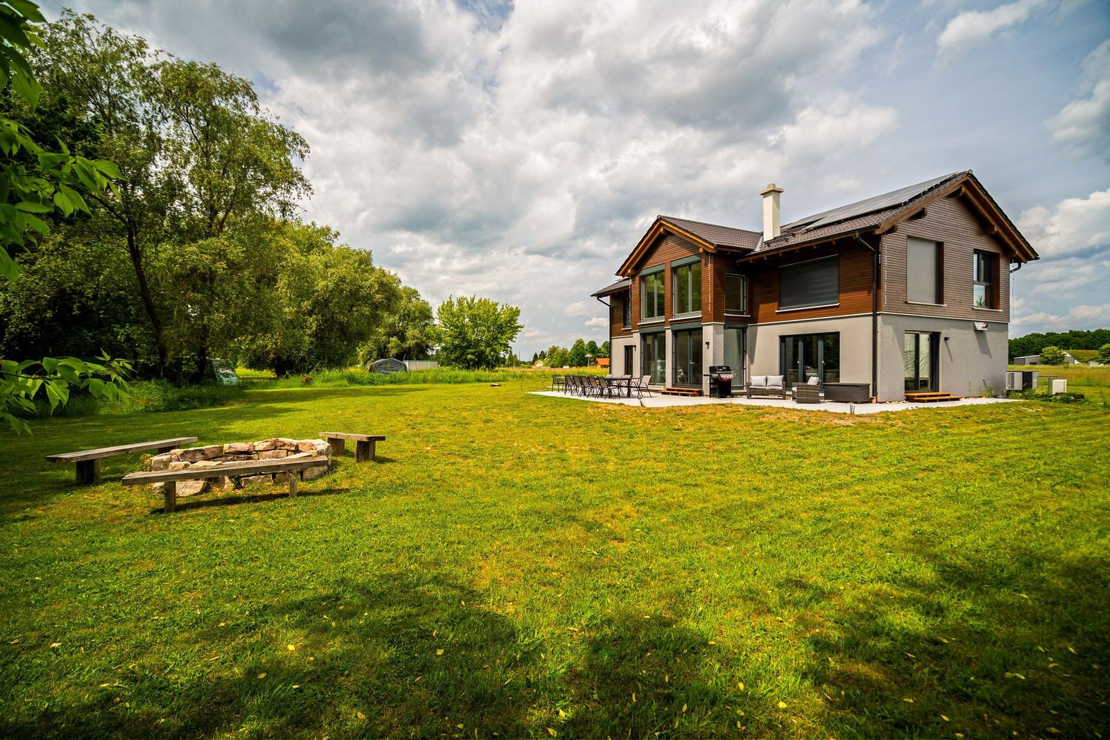 Moderne Villa mit großem Garten, Grill und Außensitzgelegenheiten.