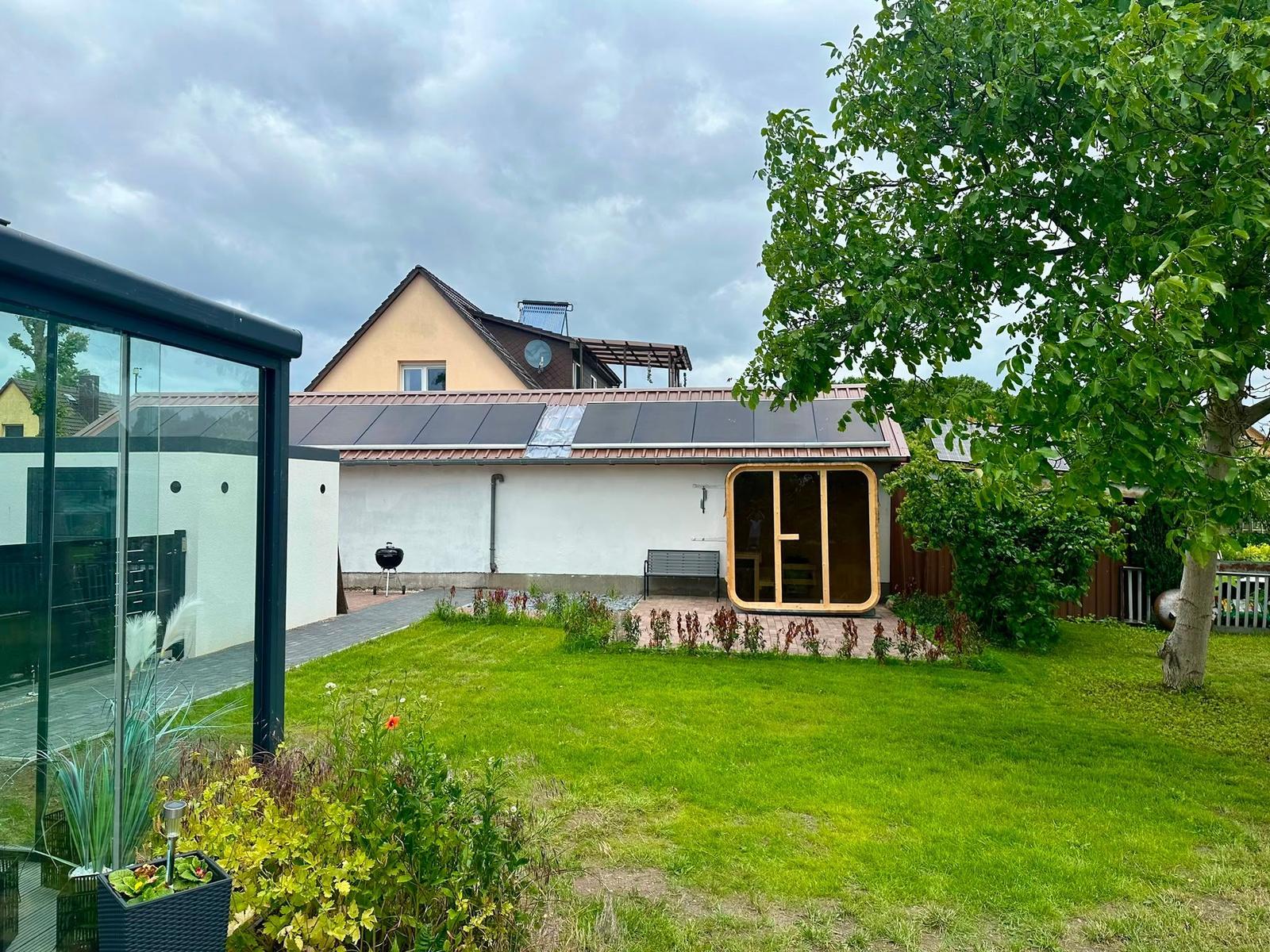 Hinterhof mit Garten, Sauna und Solaranlage auf dem Dach.