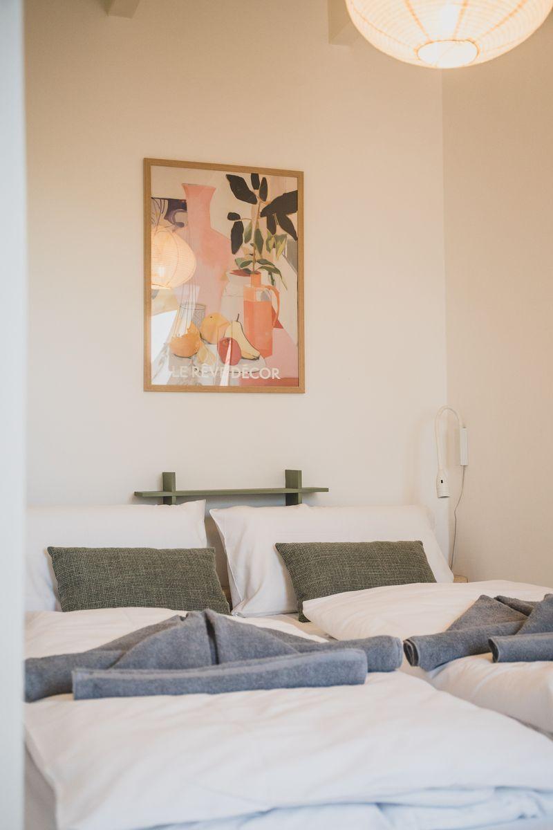Schlafzimmer mit Bett, Kissen und Wandbild