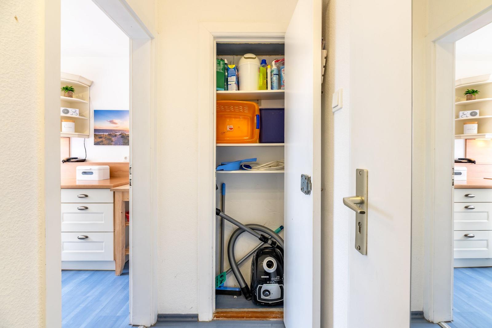 Schlafzimmer mit Kleiderschrank und Blick auf die Küche.
