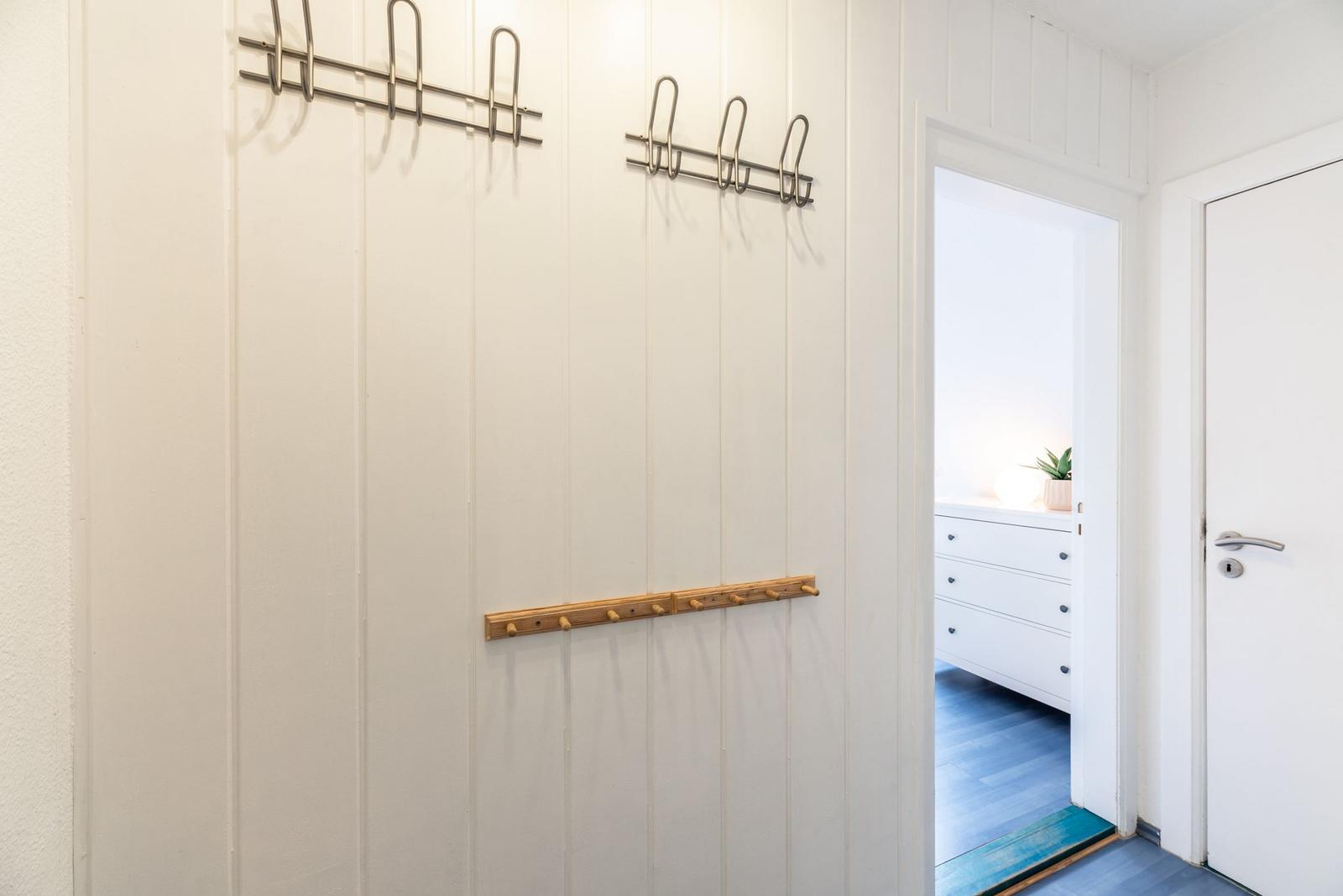 Eingangsbereich mit Haken und Tür zum Schlafzimmer